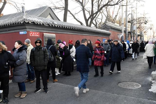 北京市民喝腊八粥祈福 雍和宫外排起百米长队