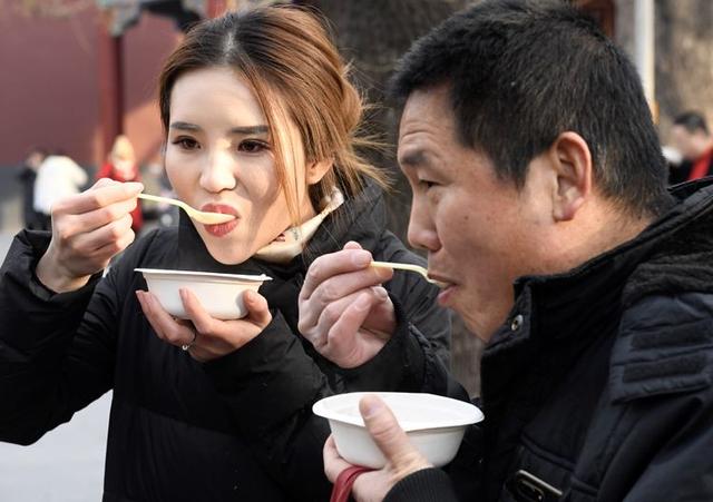 北京市民喝腊八粥祈福 雍和宫外排起百米长队