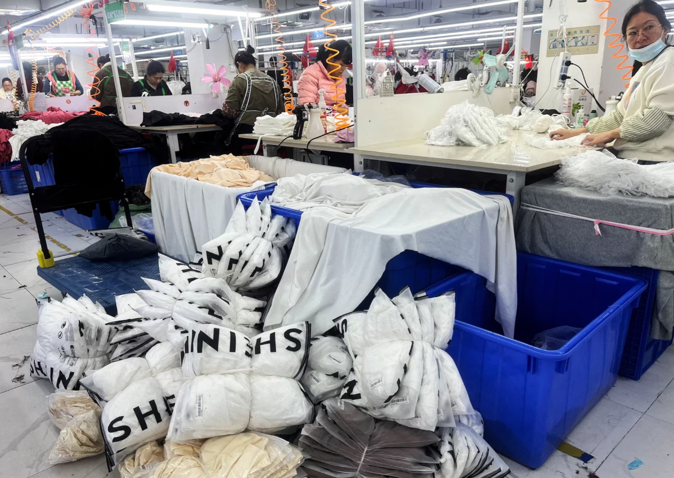 中国广东省广州市一家工厂的工人们在生产线上为 Shein 生产服装